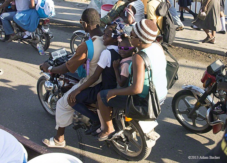 School girl in sunglasses on motorcycle, Cap Haitian, Haiti