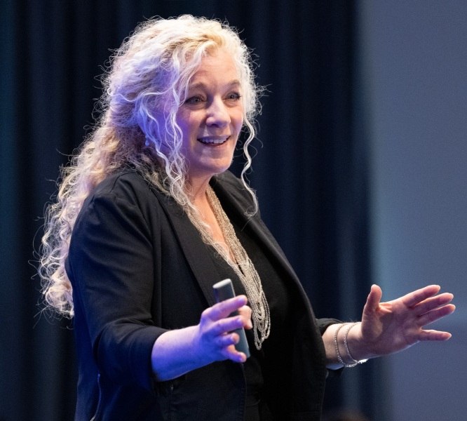 Allison Massari speaking on stage at helix Mastermind