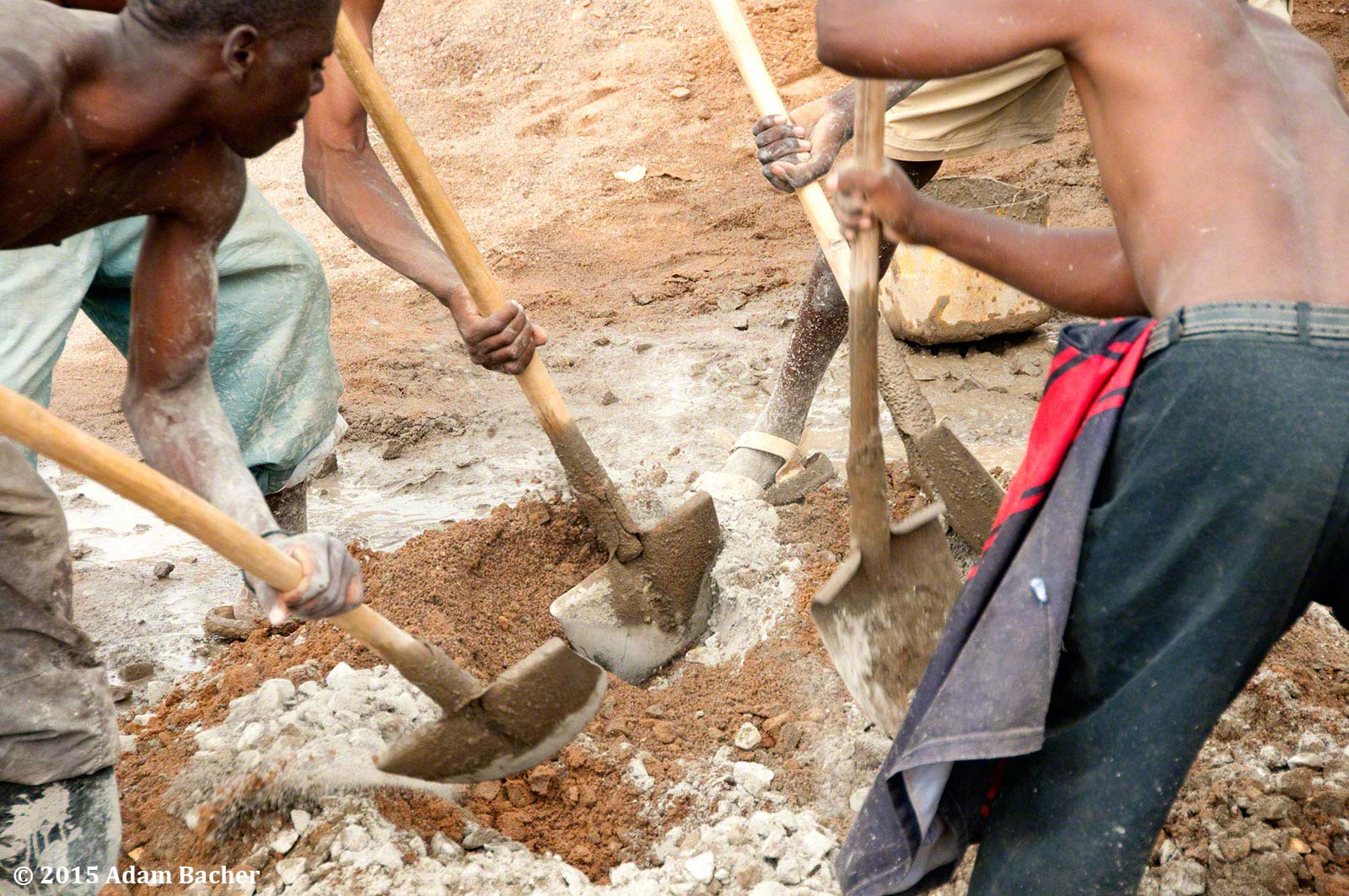 portland oregon editorial photographer in rwanda -workers shoveling cement