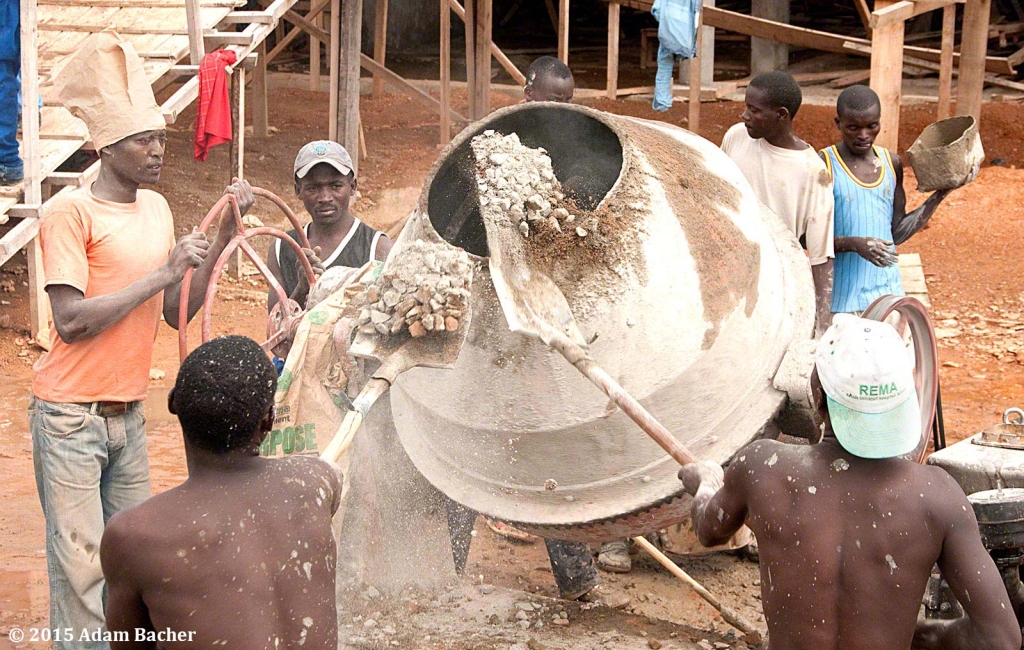 portland oregon editorial photographer in rwanda -workers shoveling cement